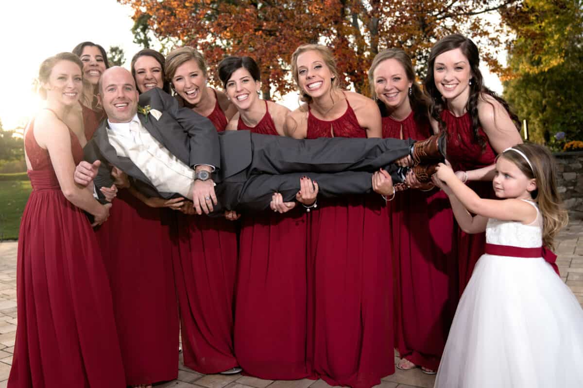 Groom poses with bridesmaids at a Hudson Valley Wedding At West Hills Country Club In Middletown, New York