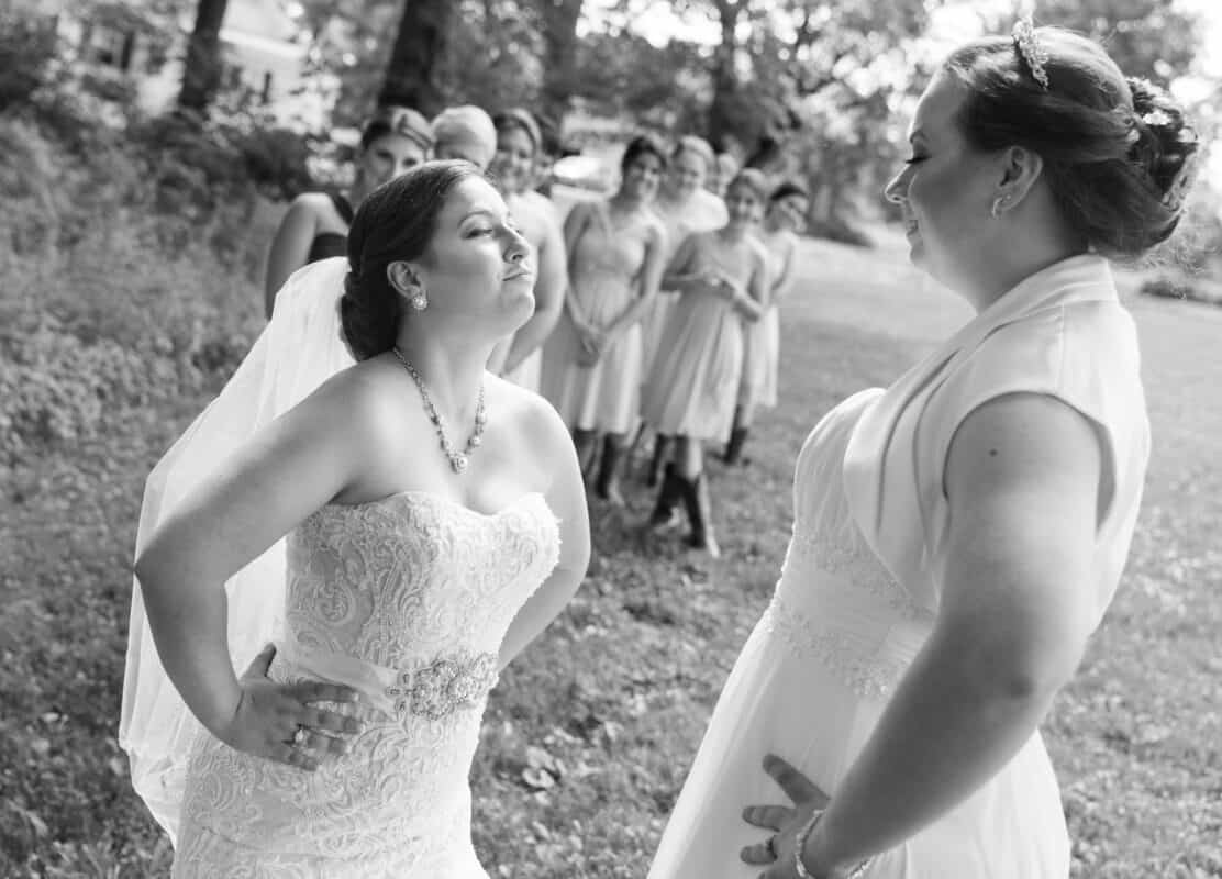 Bride smiles at bride at First look at Hudson Valley same sex wedding At Lippincott Manor in Walkill New York