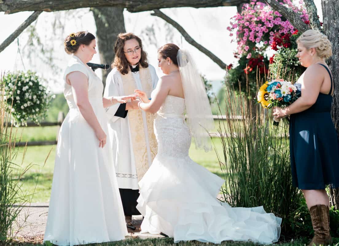 Natalie puts ring on brides hand at Hudson Valley same sex wedding At Lippincott Manor in Walkill New York