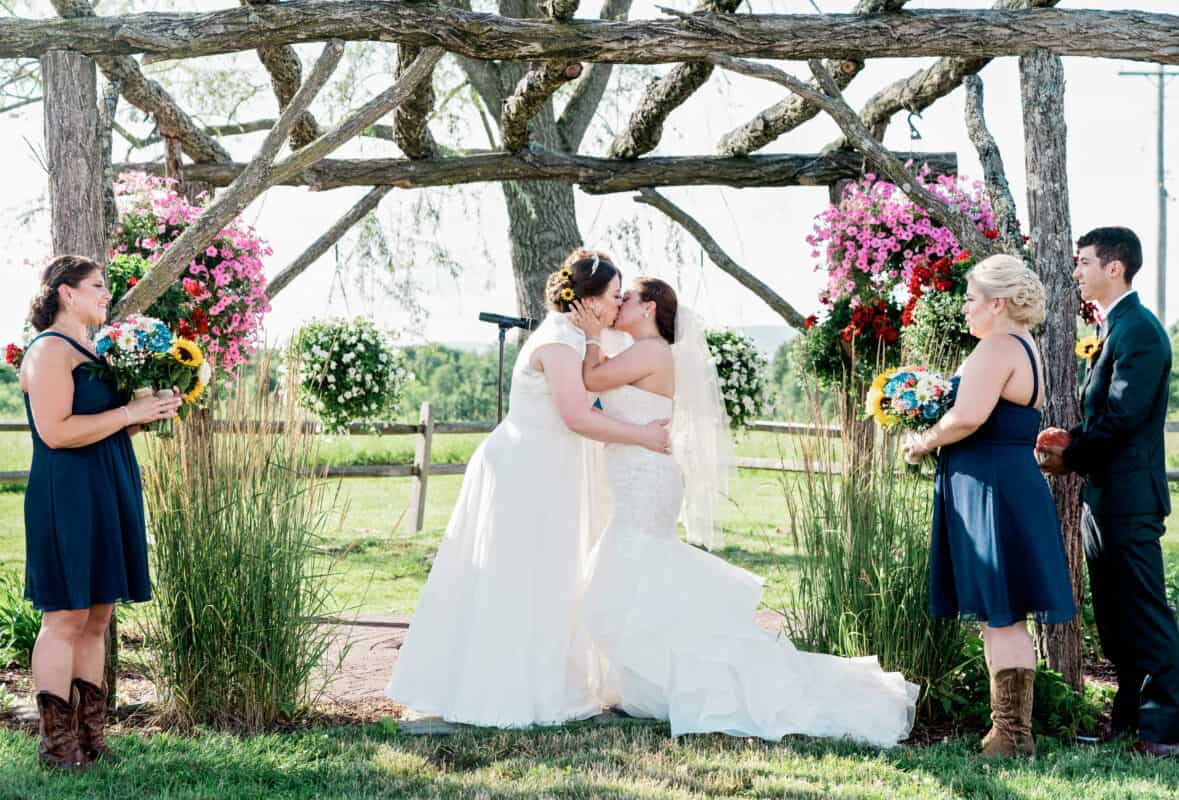 Bride and bride kiss at Hudson Valley same sex wedding At Lippincott Manor in Walkill New York
