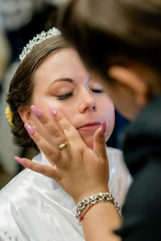Bride gets makeup while shes getting ready for her Hudson Valley same sex wedding At Lippincott Manor in Walkill New York