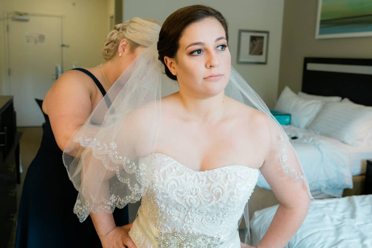 Bride looks away while getting ready for her Hudson Valley same sex wedding At Lippincott Manor in Walkill New York