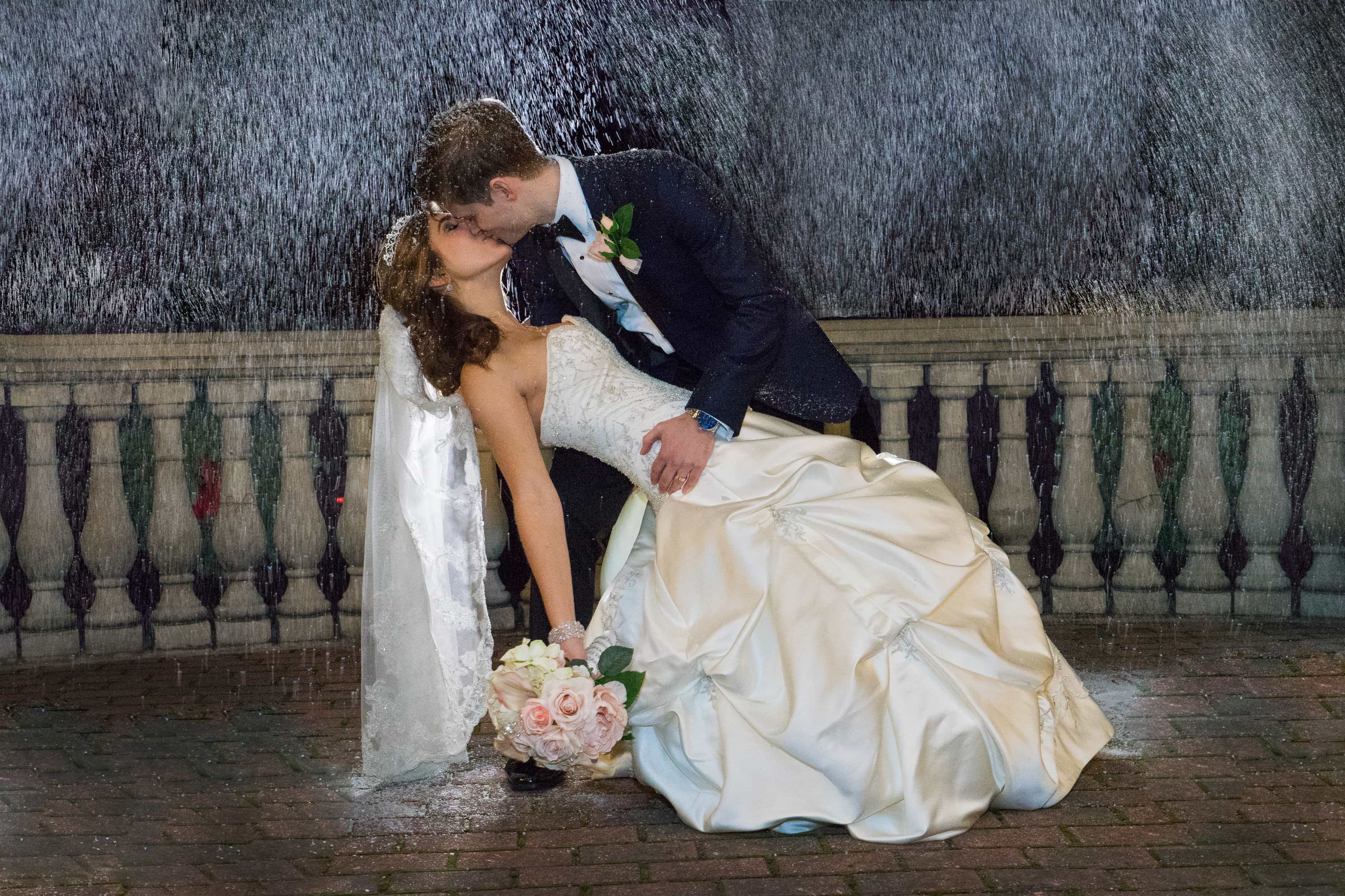 Groom dips and kisses bride in snow at a Villa Borghese Wedding in the Hudson Valley