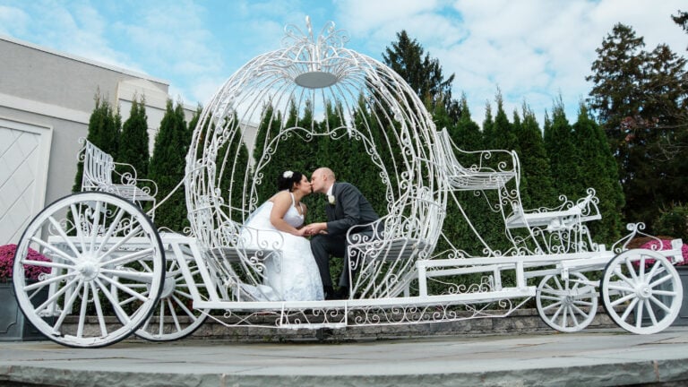 Bride and groom kiss in metal carriage at Hudson Valley Wedding at Anthony's Pier 9