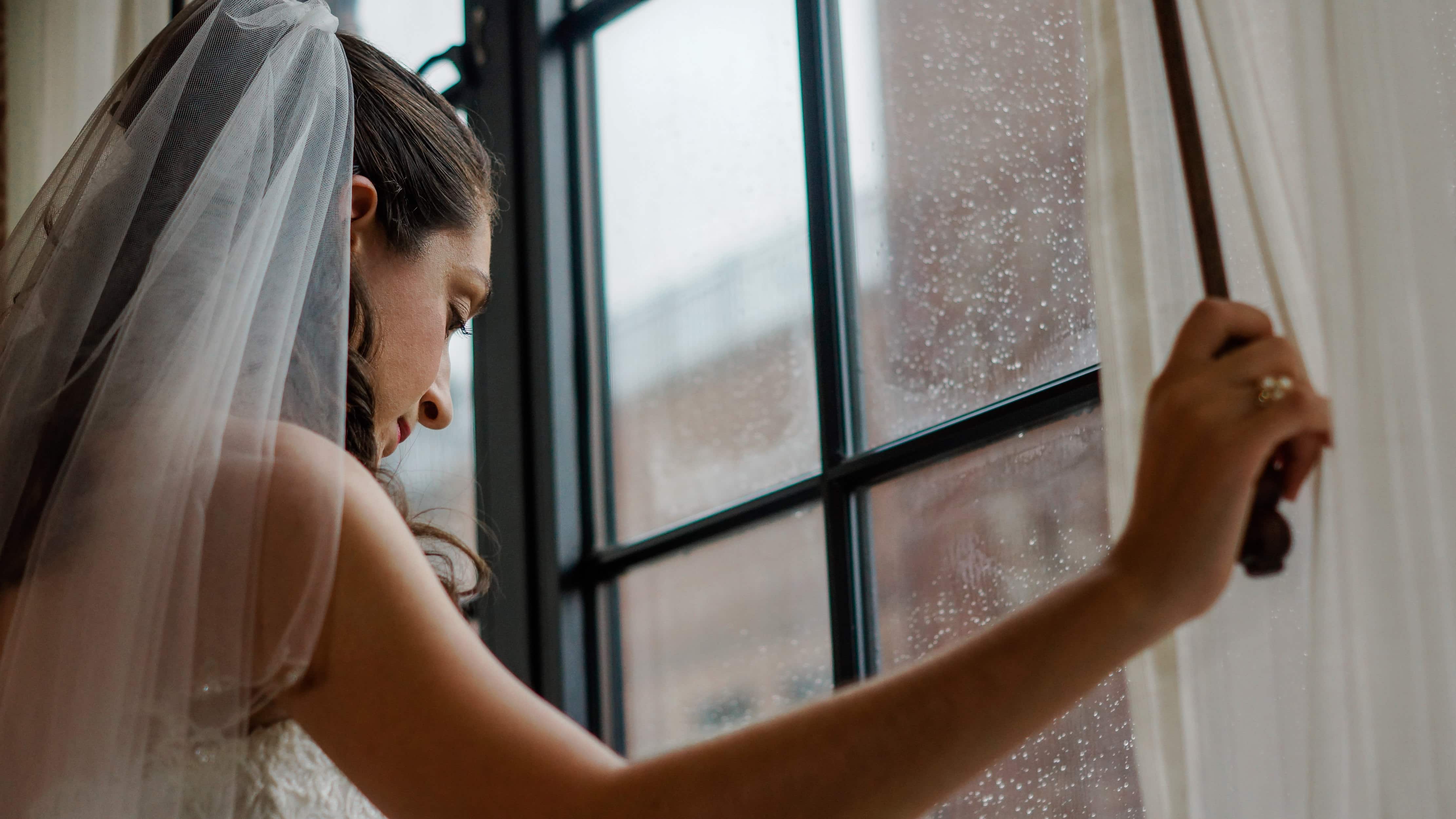 Bride Holds cord and look out window before a Torch Club Wedding in New York City