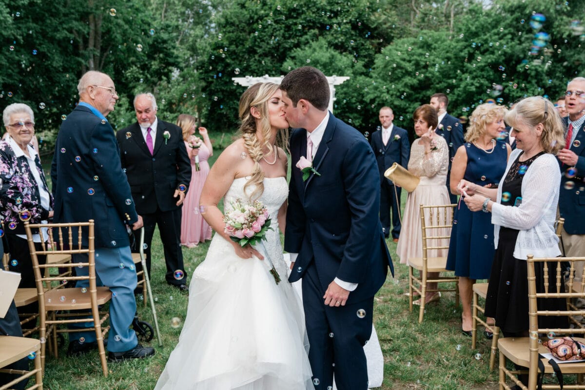Groom kisses bride surrounded by bubbles during ceremony at a Palacios Wedding in the Hudson Valley