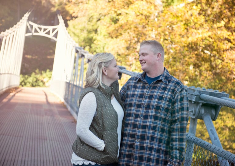 Bride and Groom hug and look into each others eyes for a photo on a Bridge for a Hudson Valley Engagement Photo