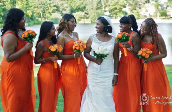 poses with bridesmaids by a lake before a Chateau Briand Wedding in Long Island