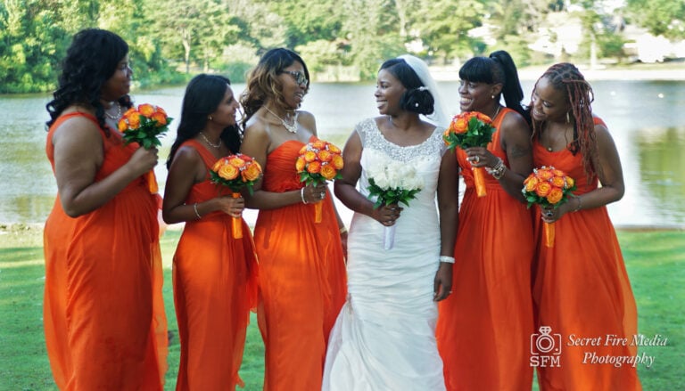 poses with bridesmaids by a lake before a Chateau Briand Wedding in Long Island