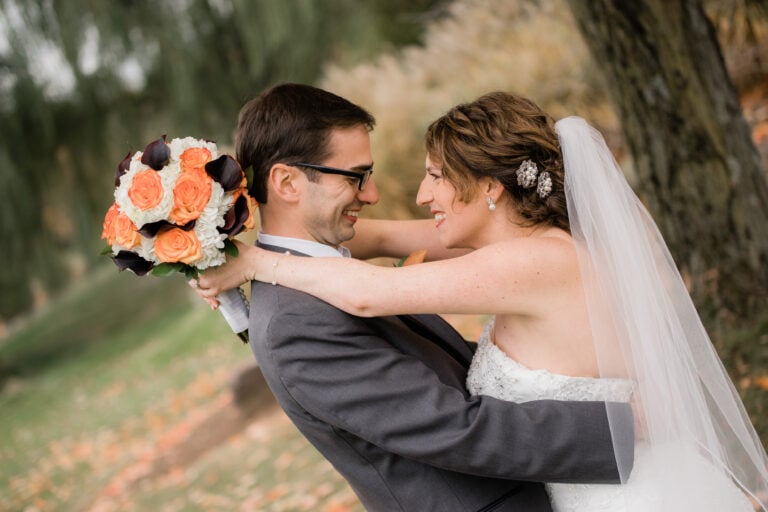 Bride and Groom hug by tree at a Hudson Valley Wedding at New York Country Club