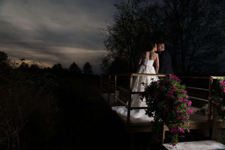 Bride and Groom kiss for photo on rustic cart at a Hudson Valley Wedding At Lippincott Manor in Walkill New York