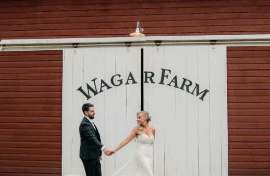 Bride and Groom hold hands by a barn at a Wedding at the Wager House for Wager House Wedding Photos