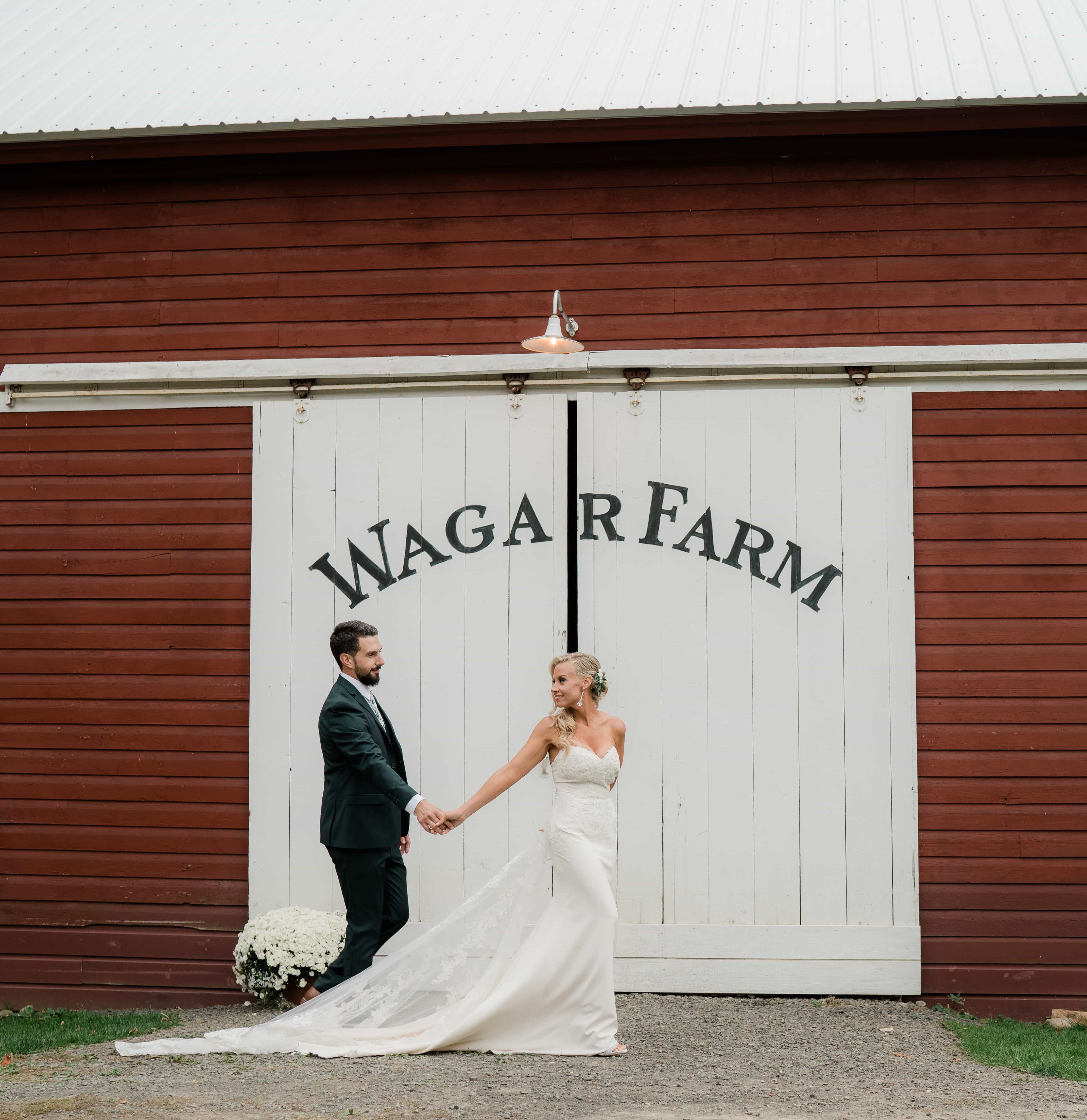 Bride and Groom hold hands by a barn at a Wedding at the Wager House for Wager House Wedding Photos