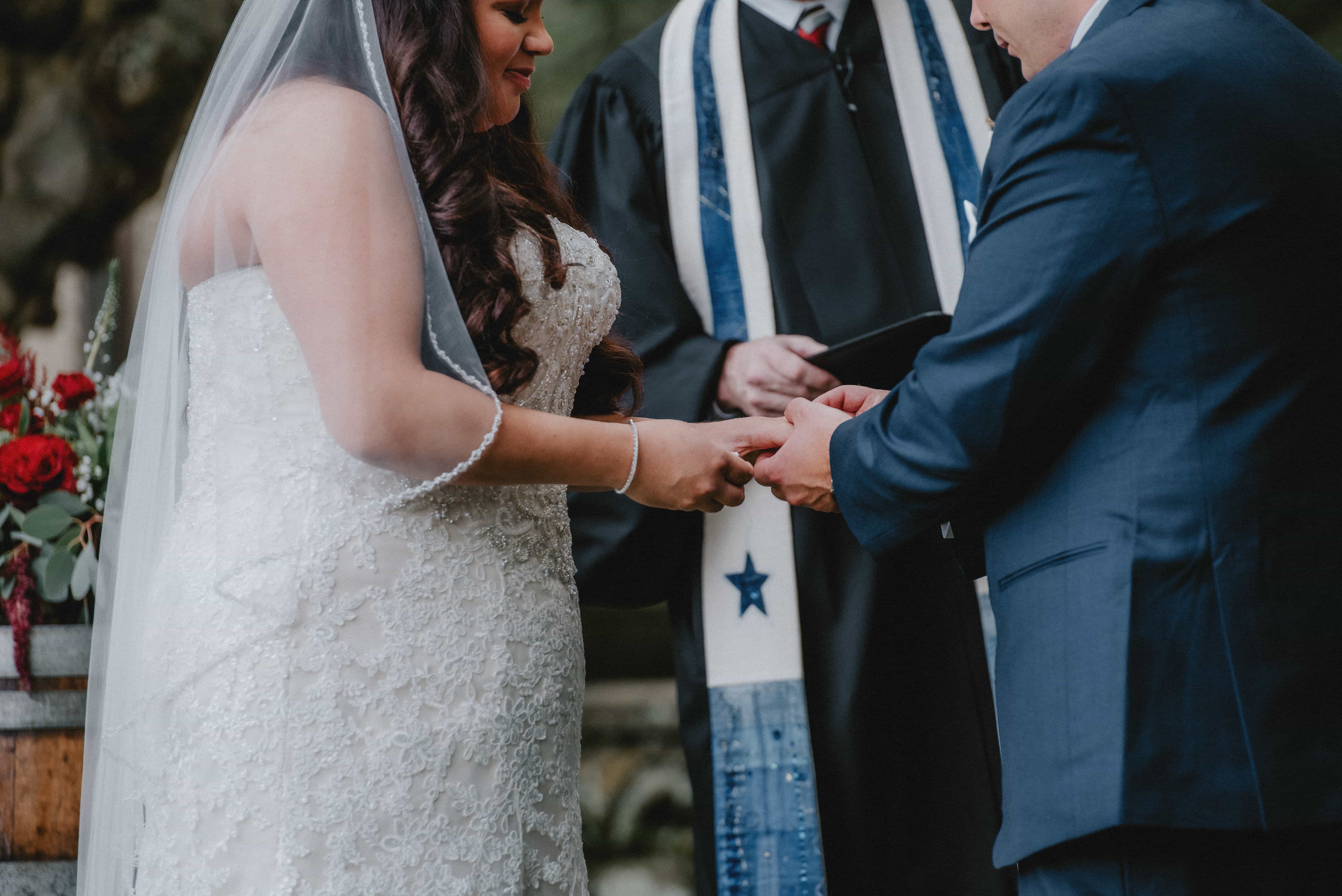 Groom puts ring on bride during Ceremony at a Hudson Valley Wedding at Brotherhood Winery