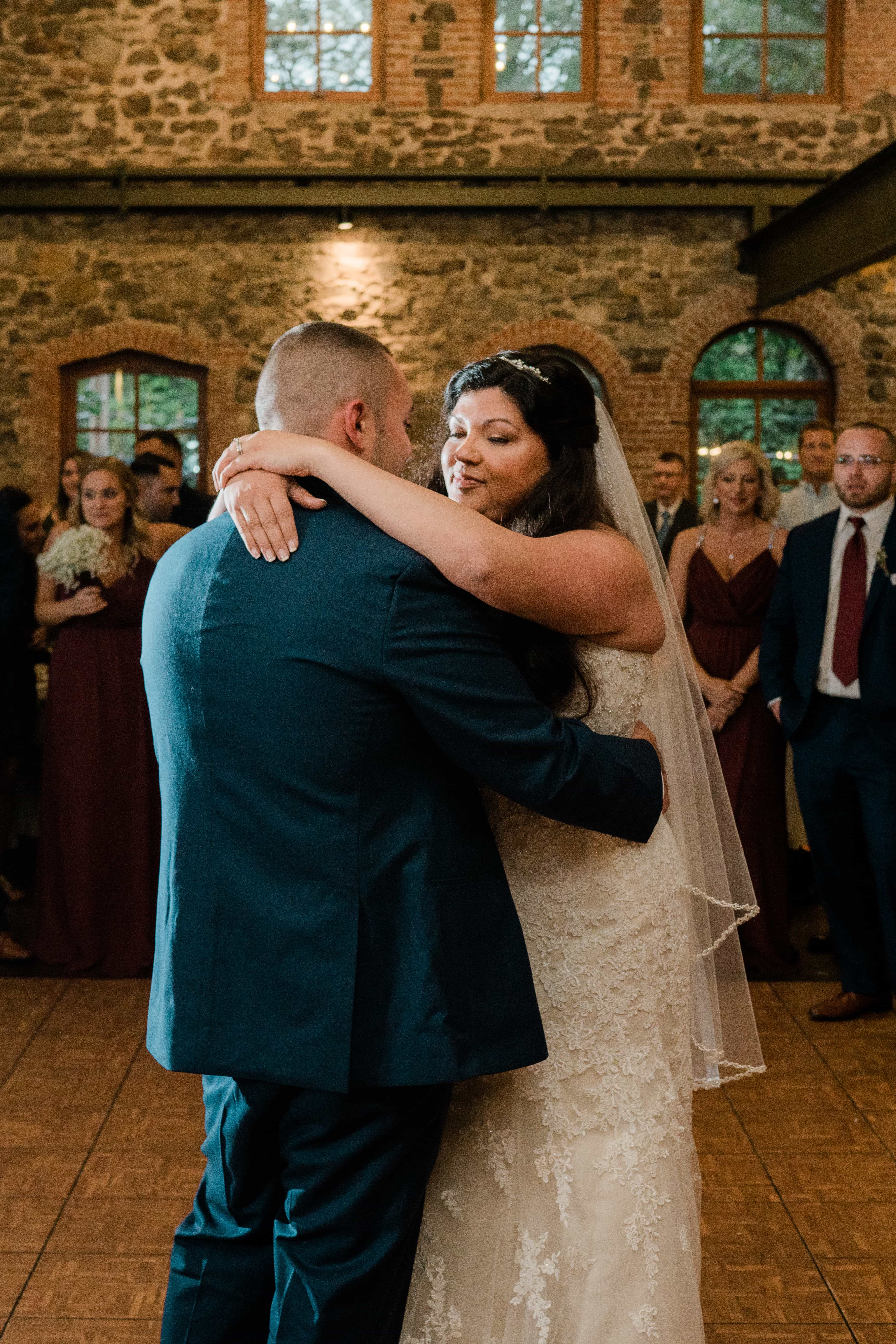 Bride smiles at groom during First Dance at a Hudson Valley Wedding at Brotherhood Winery