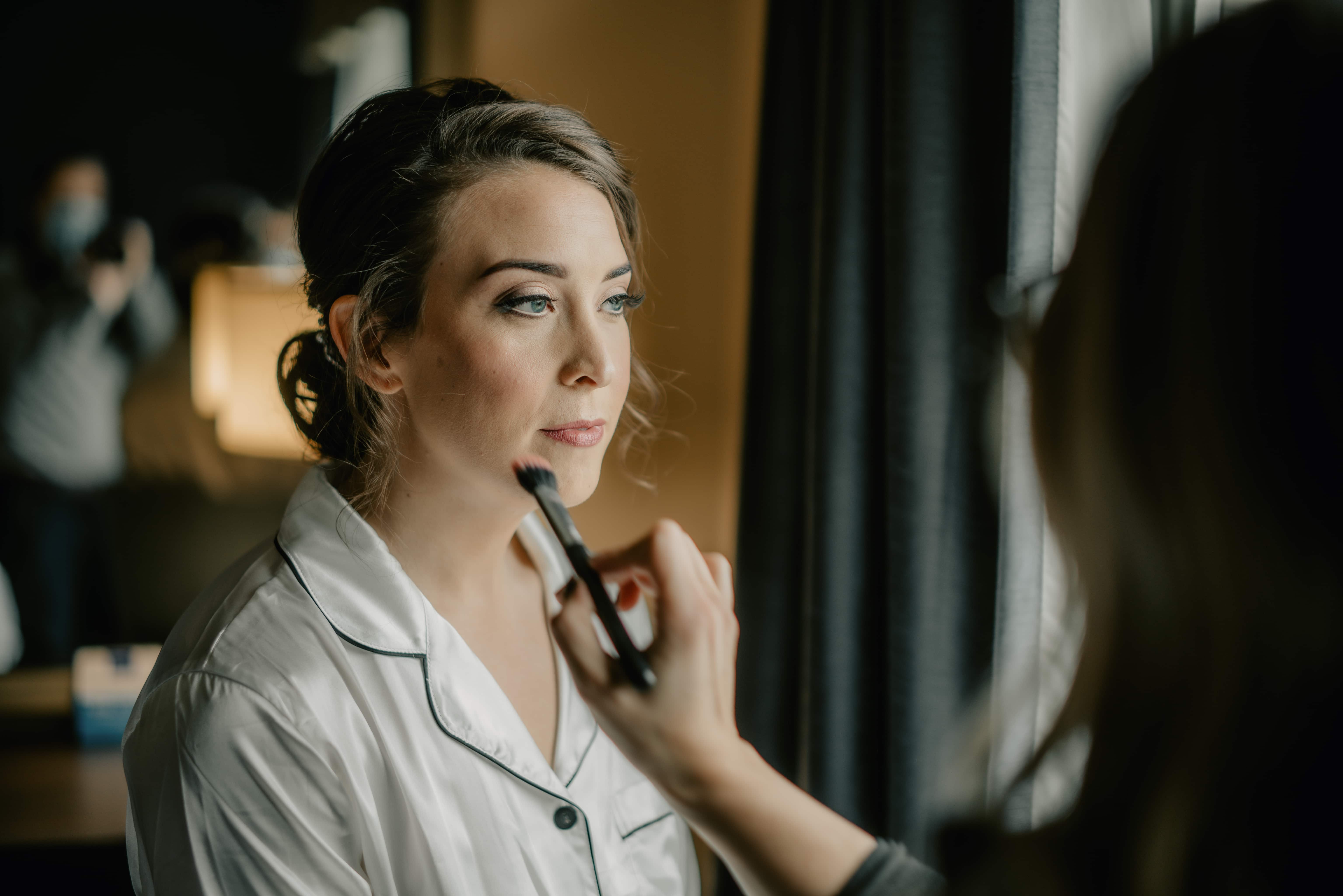 Bride gets makeup while getting ready for a Hudson Valley Wedding at Hollow Brook Country Club