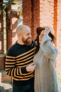Bride laughs by brick wall at Vanderbilt Estate for Hudson Valley Engagement Photography