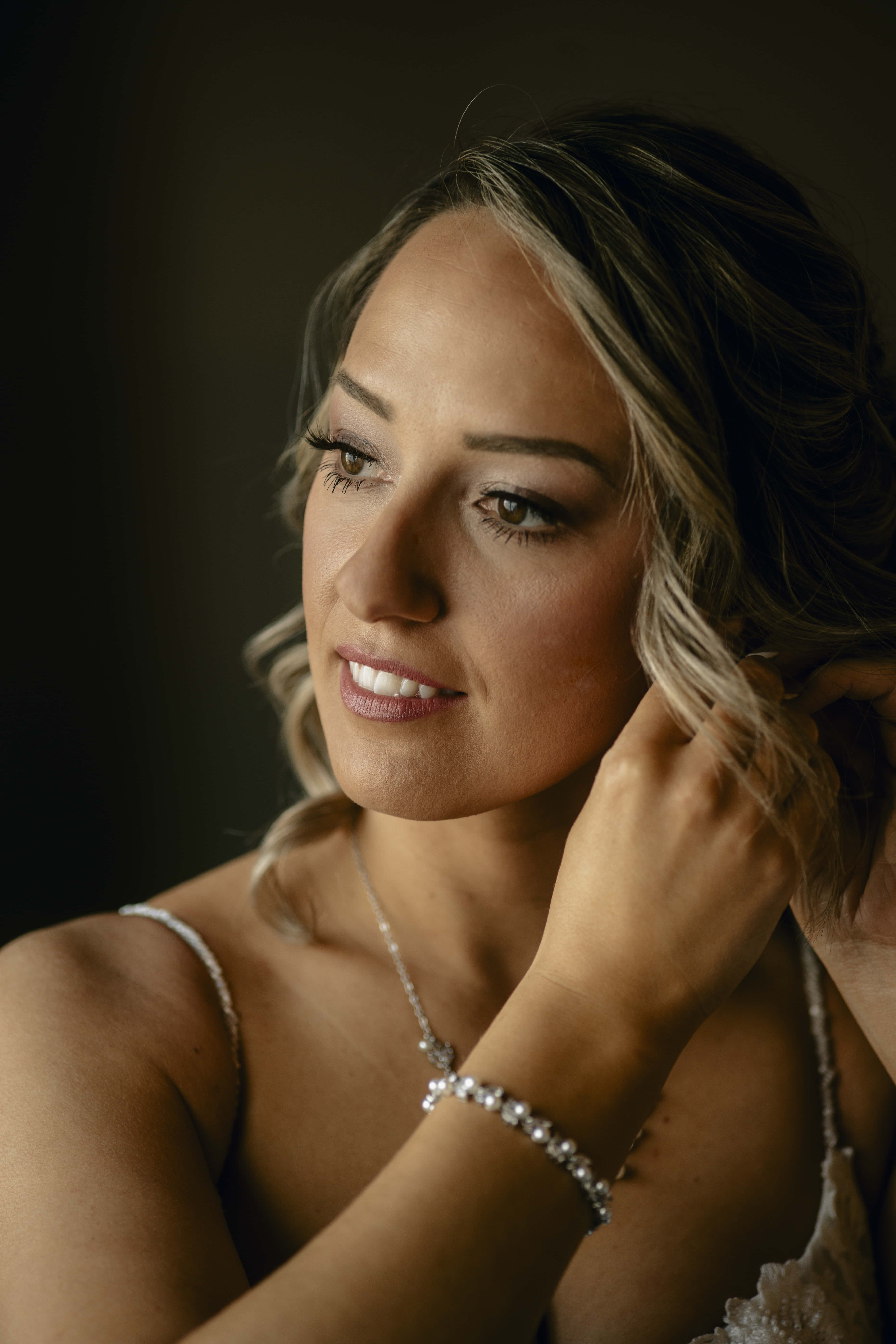 Bride puts on earrings at a Hudson Valley Wedding at Locust Grove Estate
