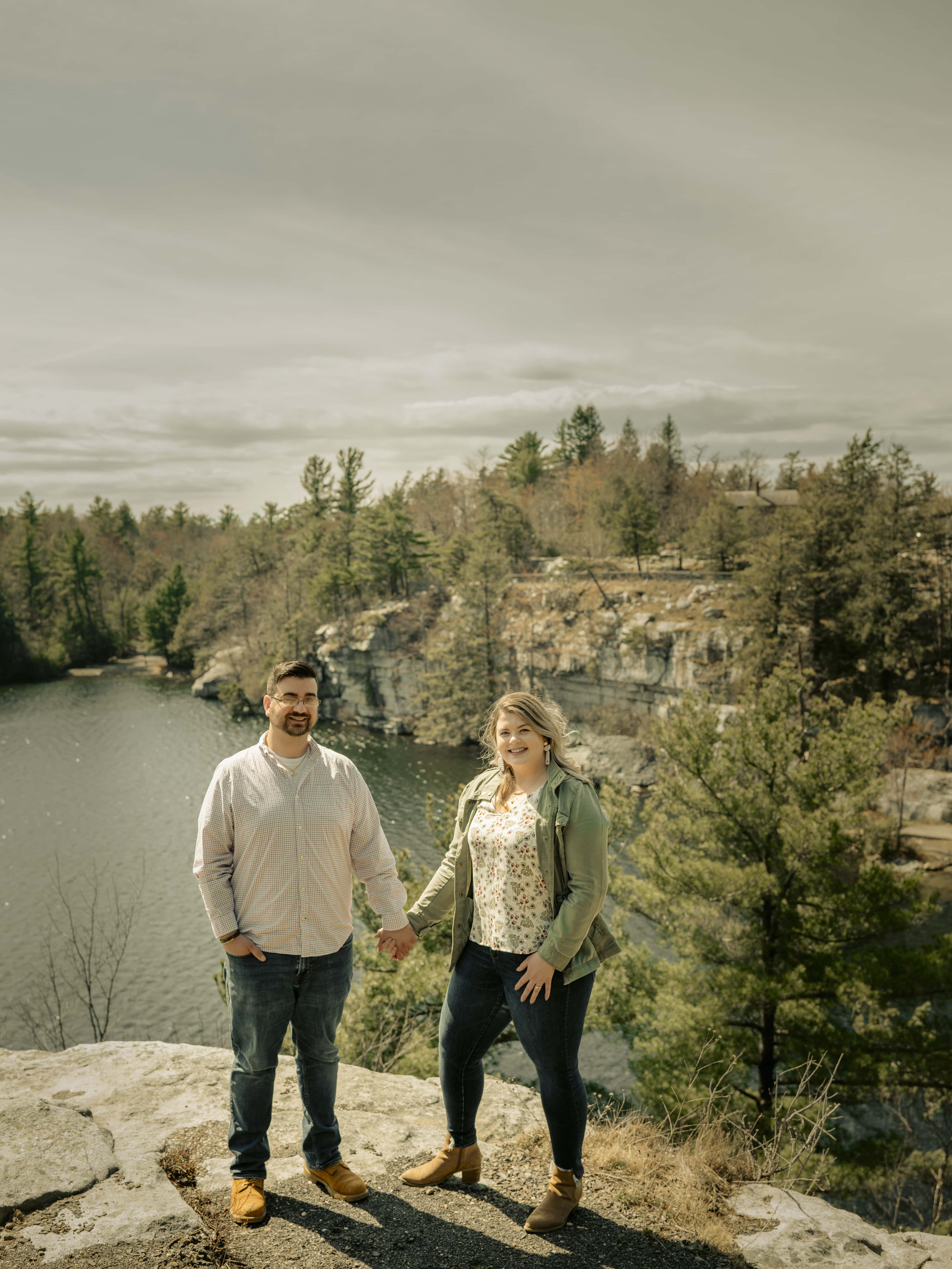 Bride and groom hold hands above lake for Lake Minnewaska Engagement Photos in The Hudson Valley