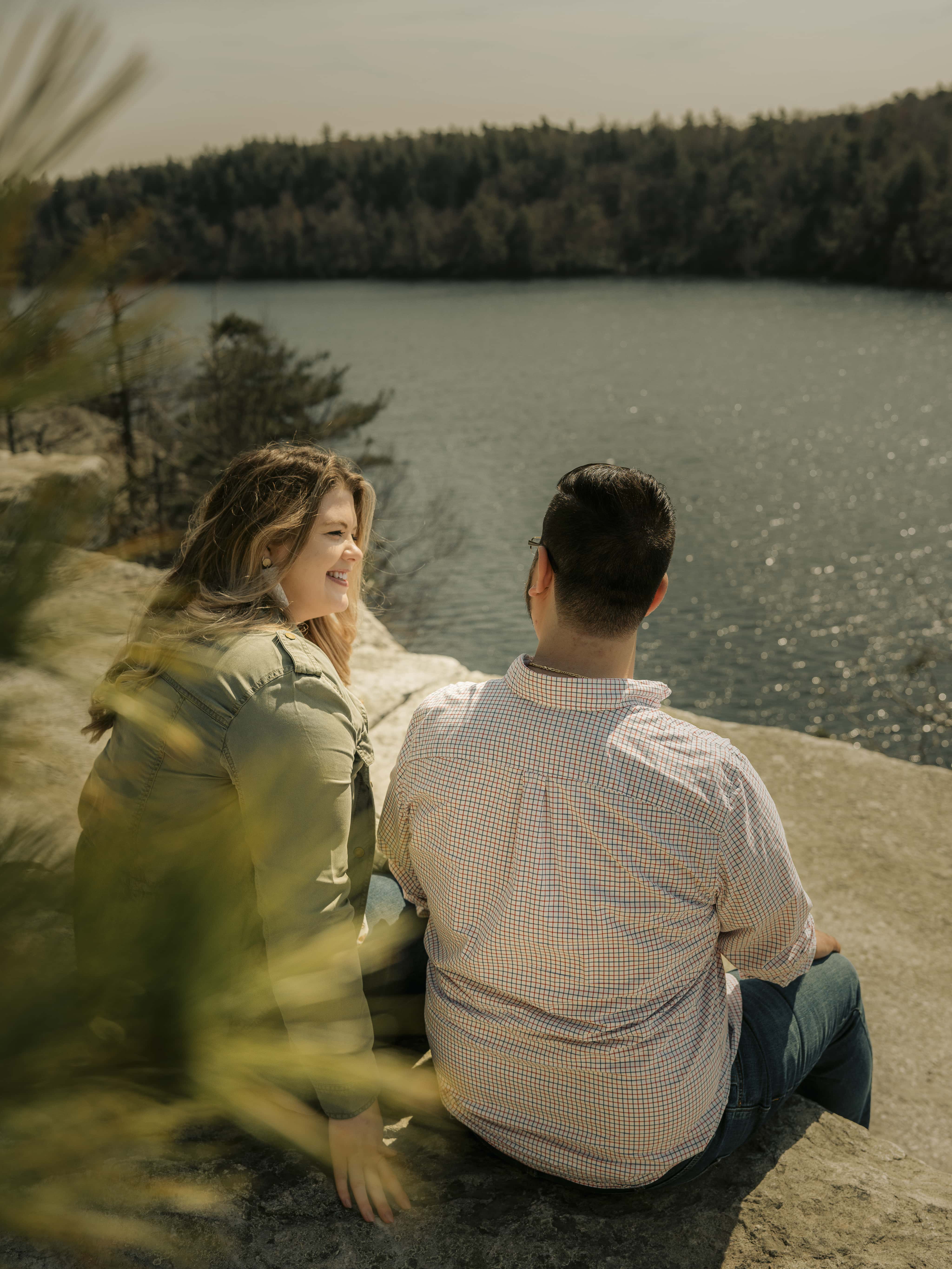 Bride and groom sit above lake for Lake Minnewaska Engagement Photos in The Hudson Valley