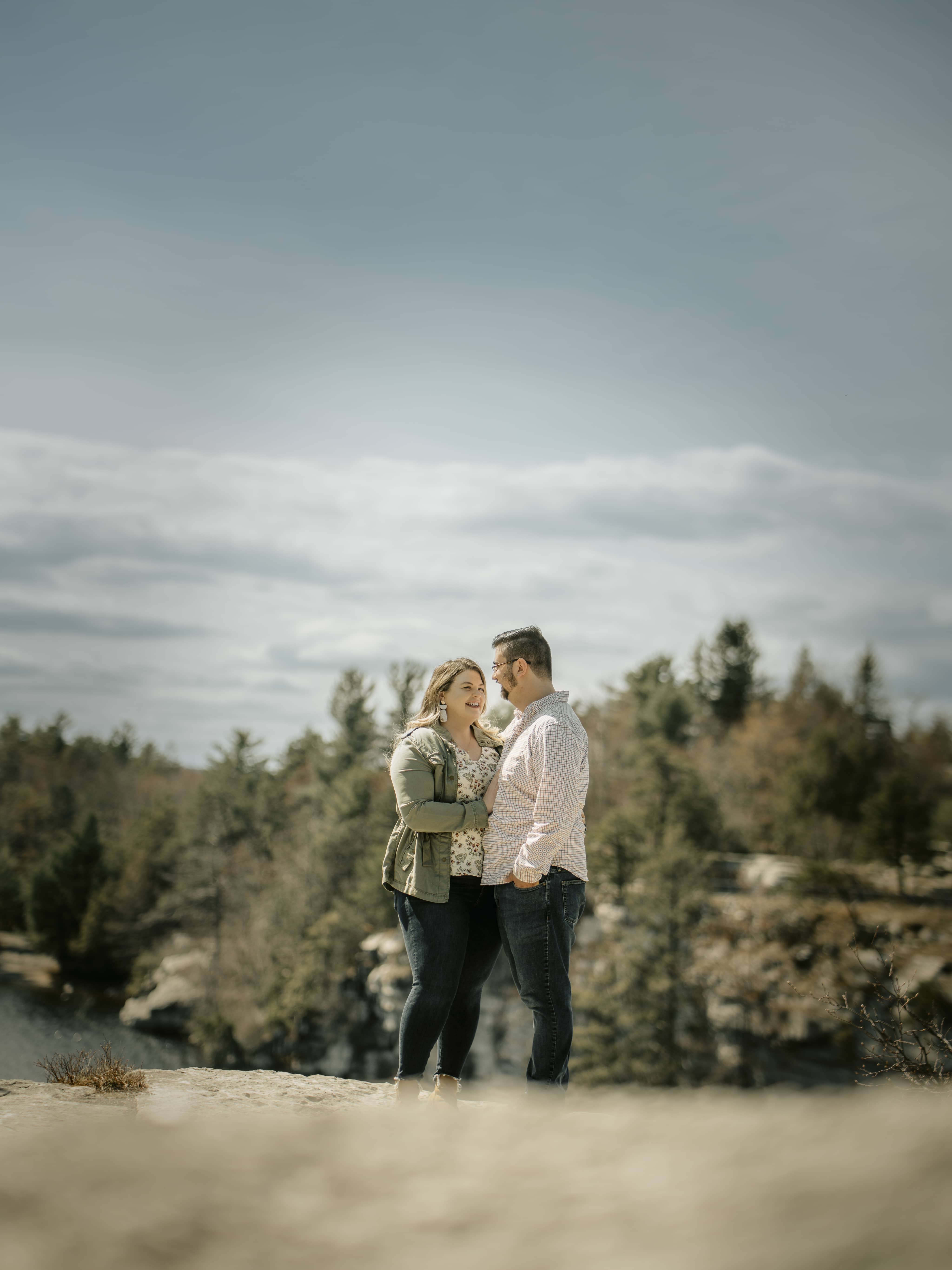 Bride and groom smile on a cliff for Lake Minnewaska Engagement Photos in The Hudson Valley