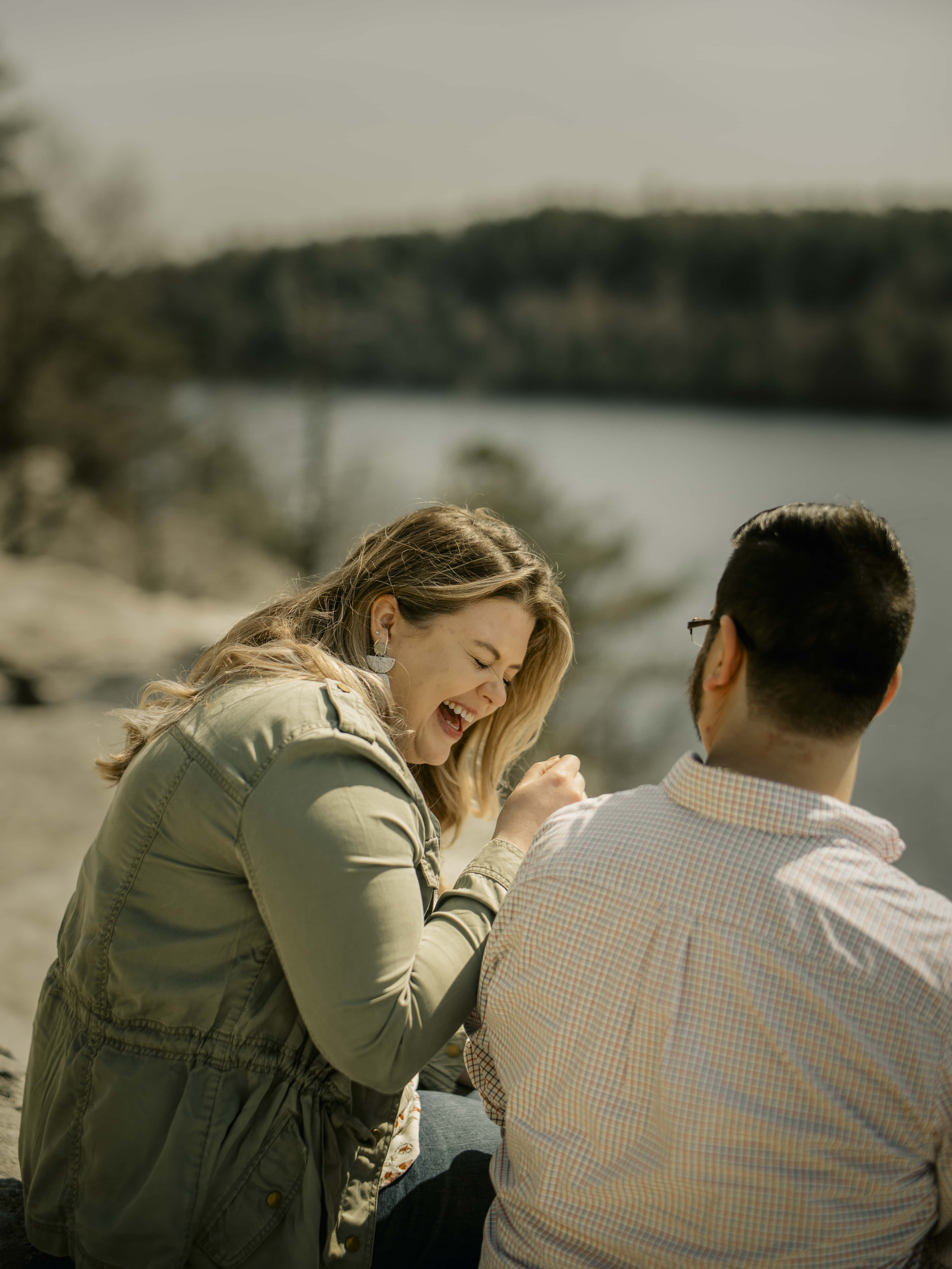 Bride laughs at groom on cliff for Lake Minnewaska Engagement Photos in The Hudson Valley