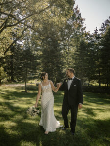 Bride and Groom walk in field and smile at a Hudson Valley Wedding at Mountainville Manor