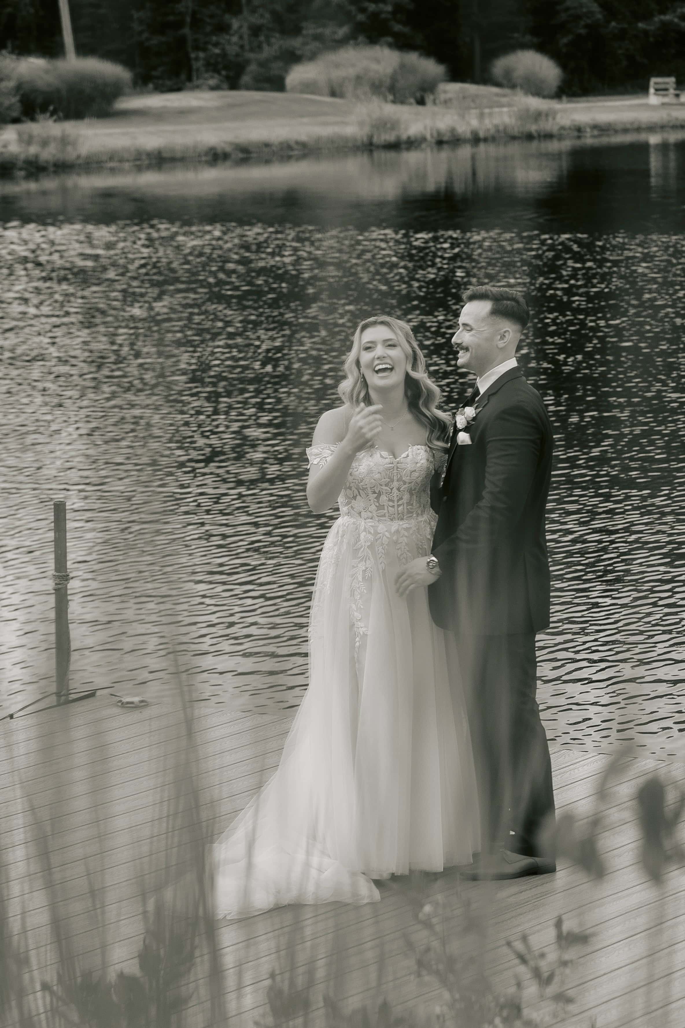 Black and White photo of bride and groom laughing on pier for a New Jersey Wedding Photo at Rock island Lake Club