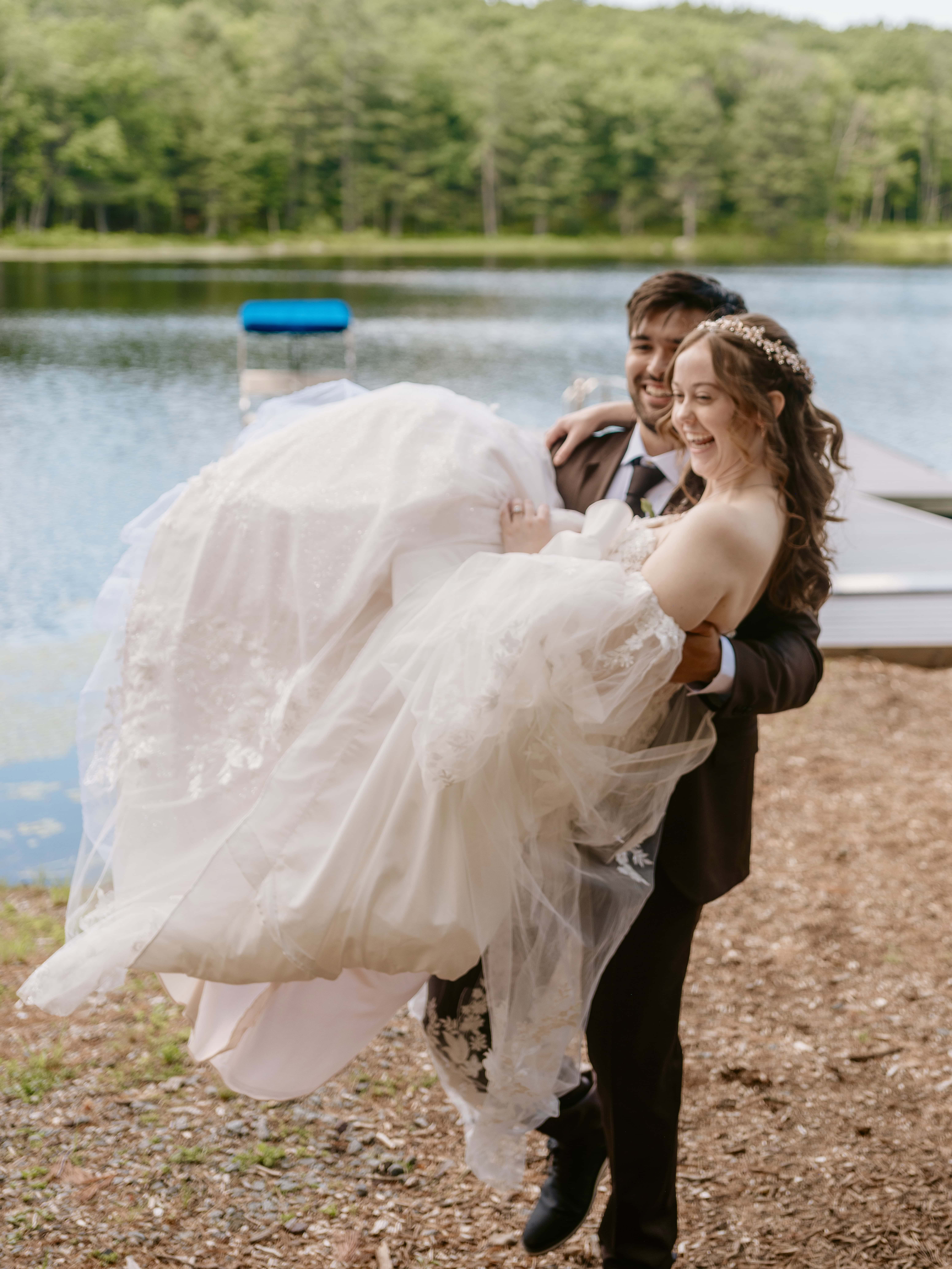 Groom carries Bride for a Hudson Valley Wedding Photo at The Eldred Preserve in the Catskills